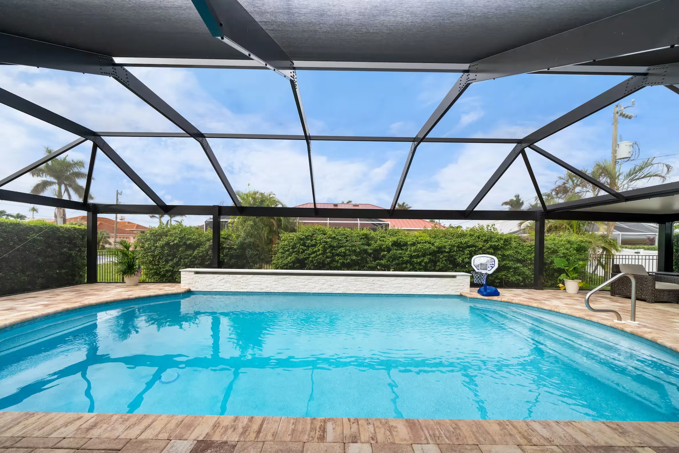 Screened pool with paver deck and water feature wall