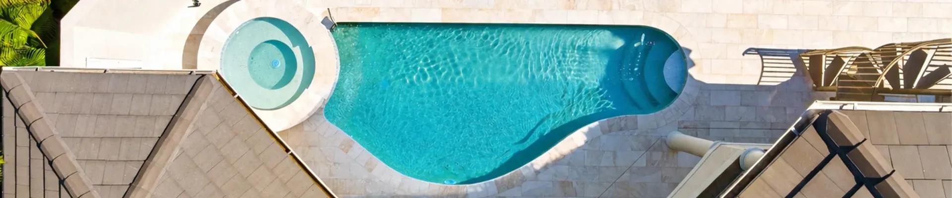 Aerial view of a pool and spa with travertine deck