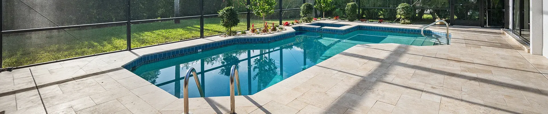 Screened pool with waterline tile and travertine deck