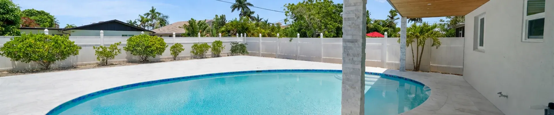 Freeform pool with new deck and blue waterline tile