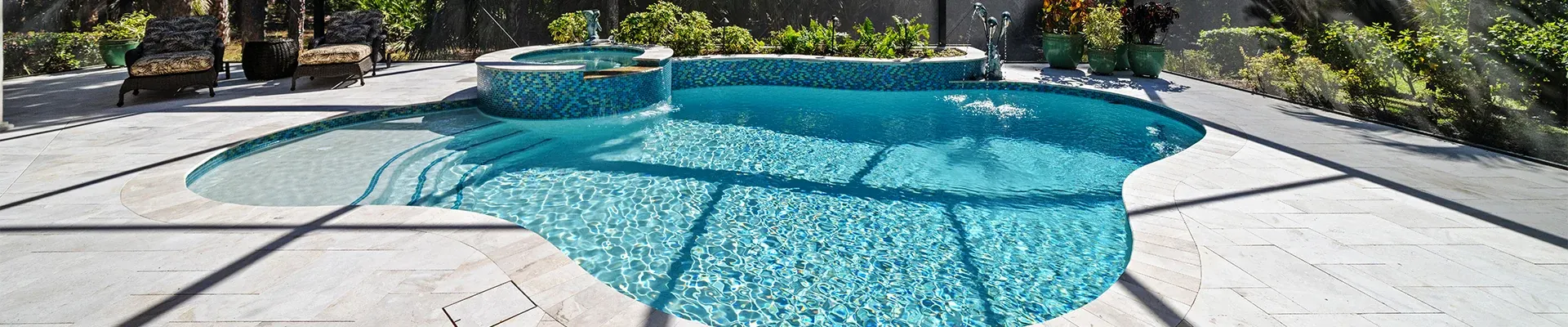 Freeform pool and raised spa with travertine deck