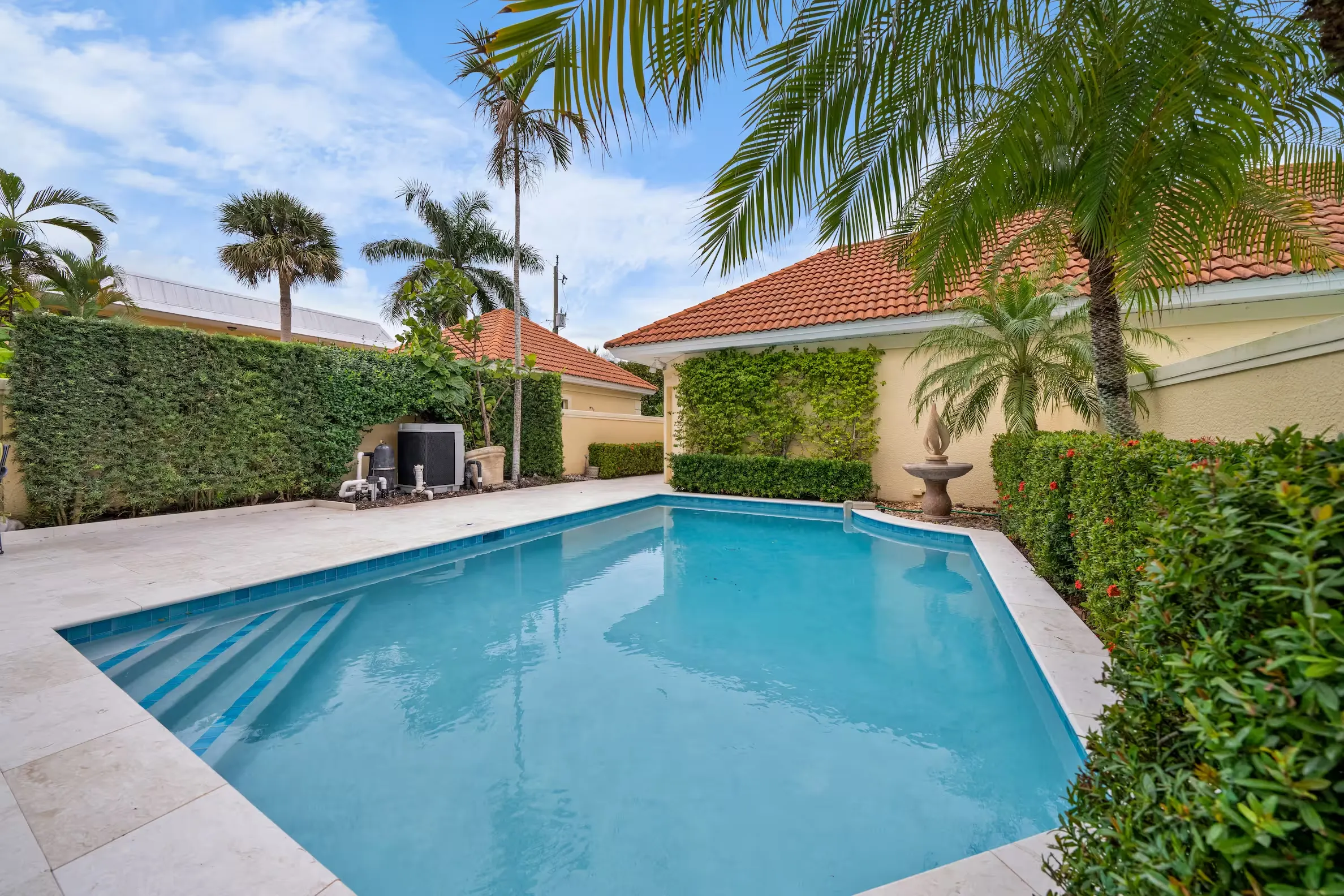 Rectangular pool with travertine deck and coping in Naples